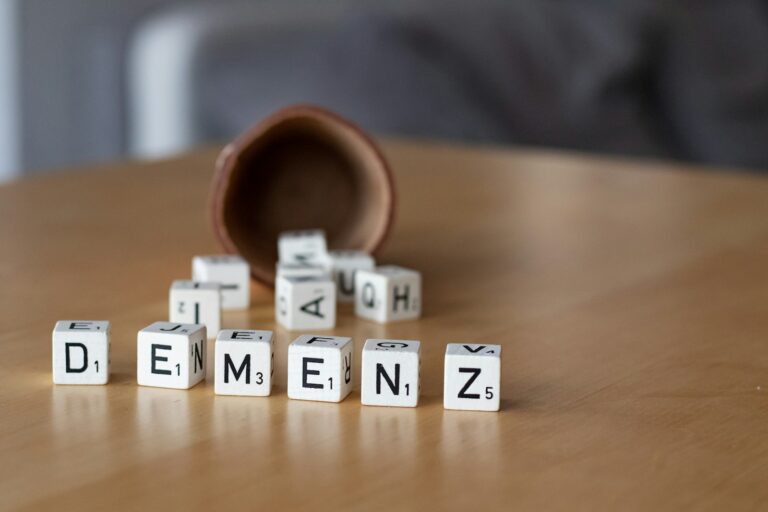 Demenz verstehen: Wie die Umgebung das Wohlbefinden beeinflusst a wooden table topped with dices and letters